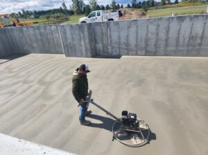 Man leveling basement with cement sander